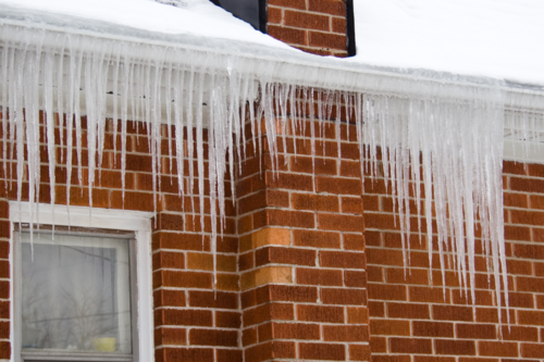 Icicles hanging on a red roof and home