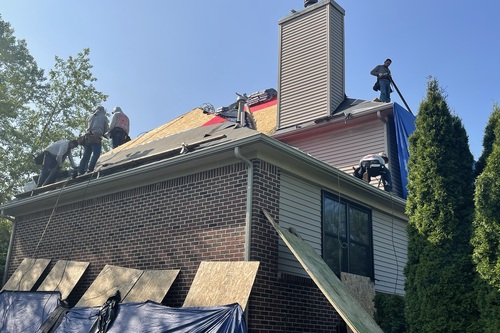 A roofing company working on a walled lake home for a roof repair