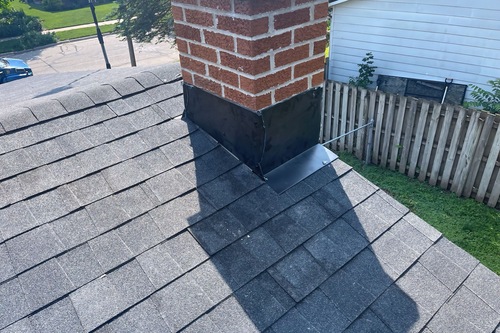 New roof installation with brick chimney. 