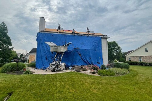 Blue tarp laid over new roof installation. 