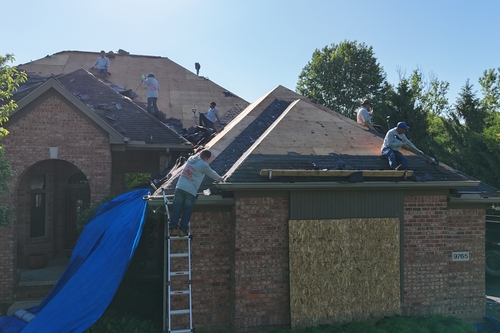 Roofman USA crew working on a roof replacement job for local Michigander homeowner